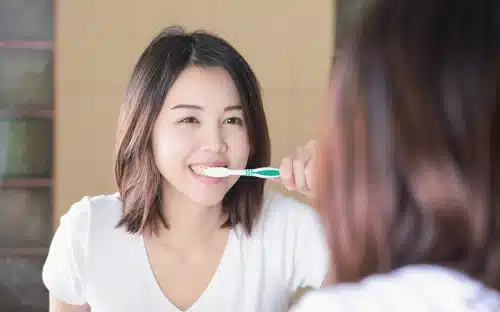 asian girl brushing teeth