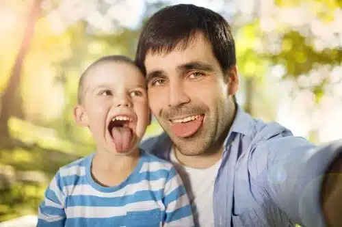 father and son spending nature selfies tongues out