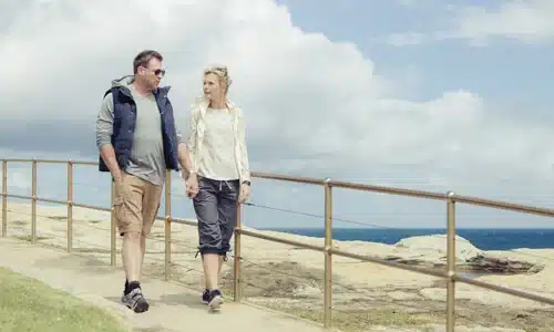 middle age couple walking down to beach