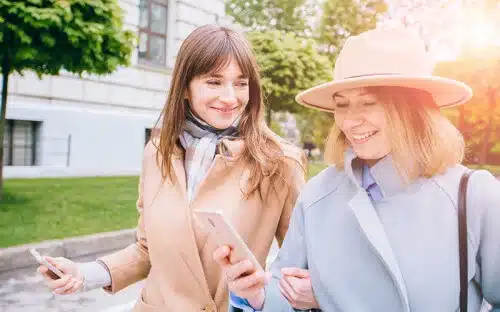 two women walking cellphones