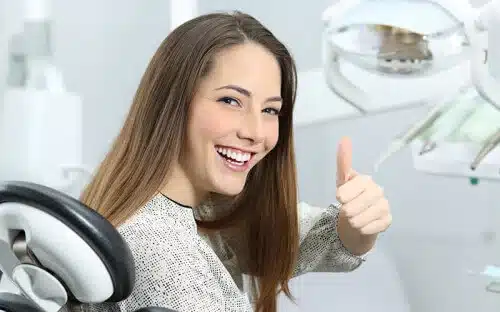 woman at dentist office thumbs up