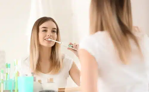 woman brushing teeth electric