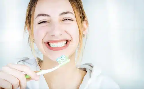 woman brushing teeth smiling