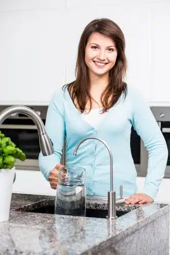 woman filling pitcher with water