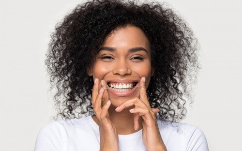 woman flossing teeth smiling