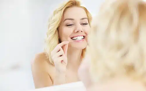 woman flossing teeth