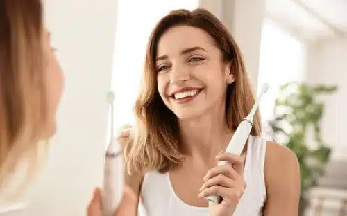 woman holding etoothbrush happy