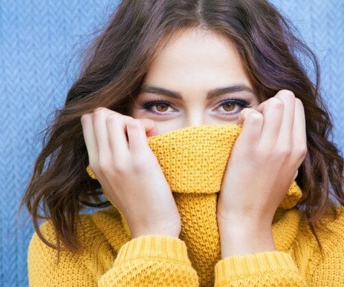 woman pulling sweater up covering mouth