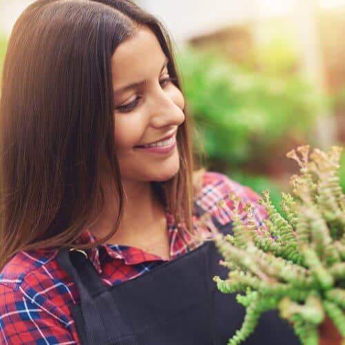 woman smiling at flowers