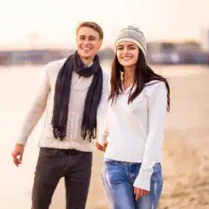 young couple walking down beach web