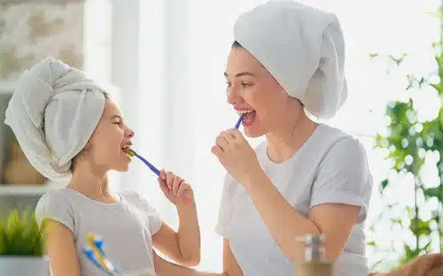 younggirl mom brushing teeth